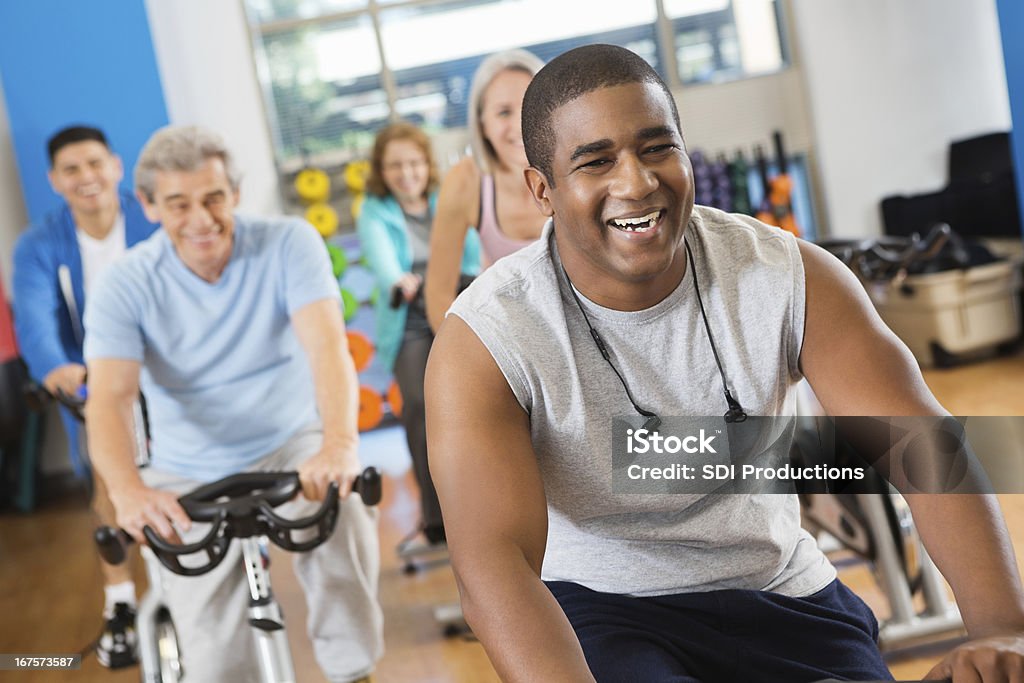 Heureux jeune homme menant son club de remise en forme de vélo de classe - Photo de Adulte libre de droits