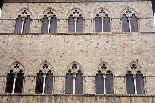 Bologna, Emilia-Romagna, Italy, - Feb 23th, 2020: Closeup of two mullioned windows (trifore - triple lancet) of the medieval Palazzo Re Enzo (King Enzo palace, 1245) in Piazza del Nettuno, Bologna downtown, Emilia-Romagna, Italy, Europe