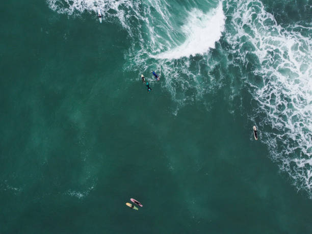 istock Surfers on transparent blue ocean water 1675749327