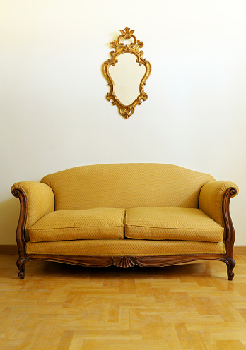 Vintage sofa and golden mirror.