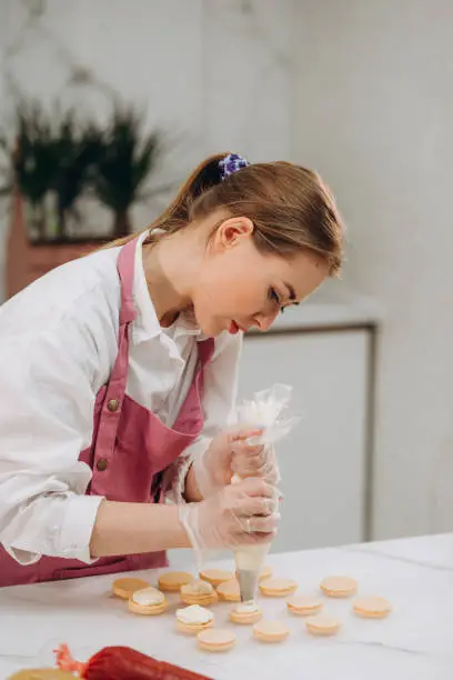 A confectioner makes macaroons in a pastry shop. High quality photo
