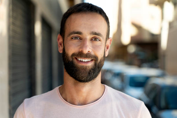 istock Handsome smiling hispanic man looking at camera standing on urban street 1675780554