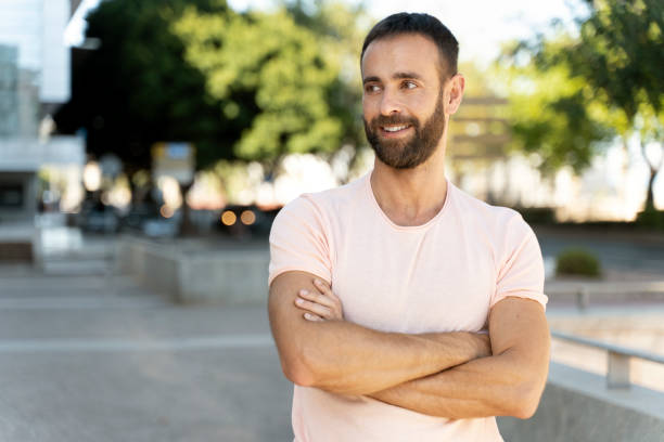 istock Handsome hispanic man with arms crossed looking away outdoors, copy space 1675780649
