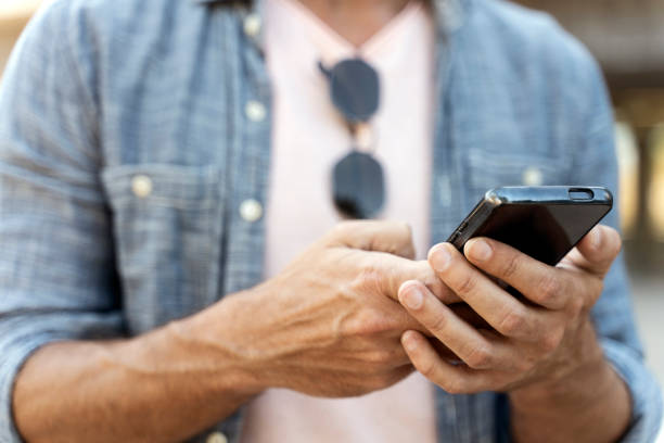 istock Man hands using mobile app shopping online, checking email, sending text message outdoors 1675780747
