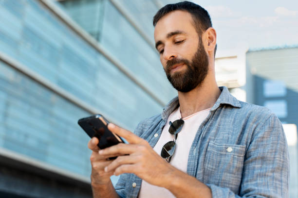 istock Man using mobile phone communication online, reading text message on the street 1675780750