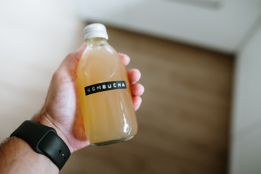 Fresh orange juice in no label clear plastic bottle with a green cap   against the backdrop of a garden with orange trees. Citrus juice on an orange plantation. Concept: no preservatives,freshly squeezed