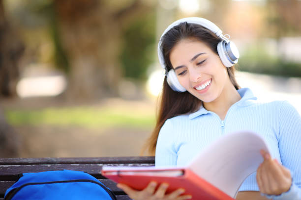 istock Happy student listening lesson in a park 1675818273