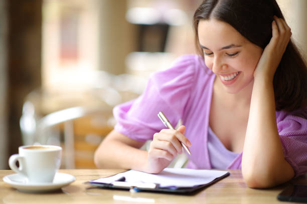 istock Happy woman reading and filling form 1675818310