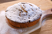 Muffin cake decorated icing sugar  on a wooden table and board.