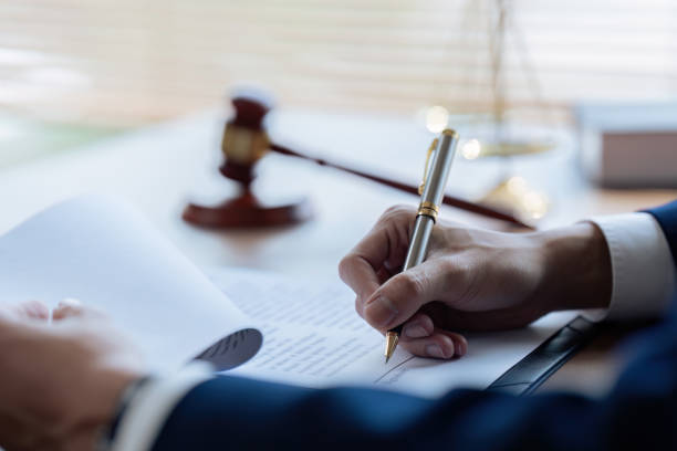 istock Lawyer leafing through documents and signing contract at work in office 1675849874