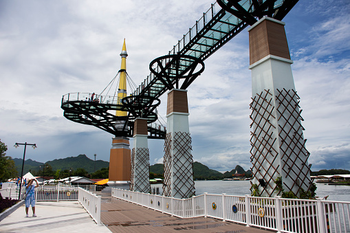 Skywalk bridge stretching parallel to banks of Khwae Yai or Si Sawat river for thai people foreign travelers travel visit and walking on clear glass bridge on August 30, 2023 in Kanchanaburi, Thailand
