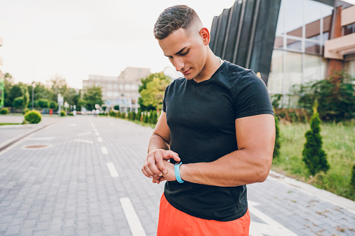 Athlete Checking Fitness Activity On Fitness Tracker After Working Out Outdoors