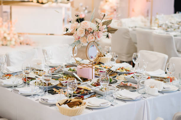 istock Wedding setup. Table setting serving. Banquet decoration in hall restaurant. Luxury reception. Festive table decorated composition flowers in party area. Golden geometric decorative sign number table. 1675866632