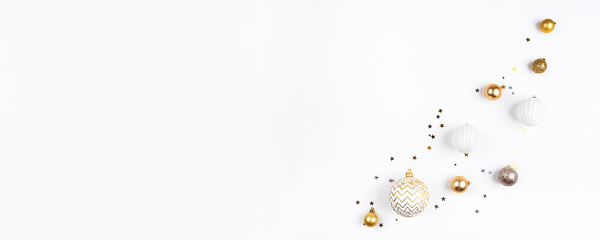 Festive white background with gold Christmas decorations. Flat lay, top view. Copy space for text.