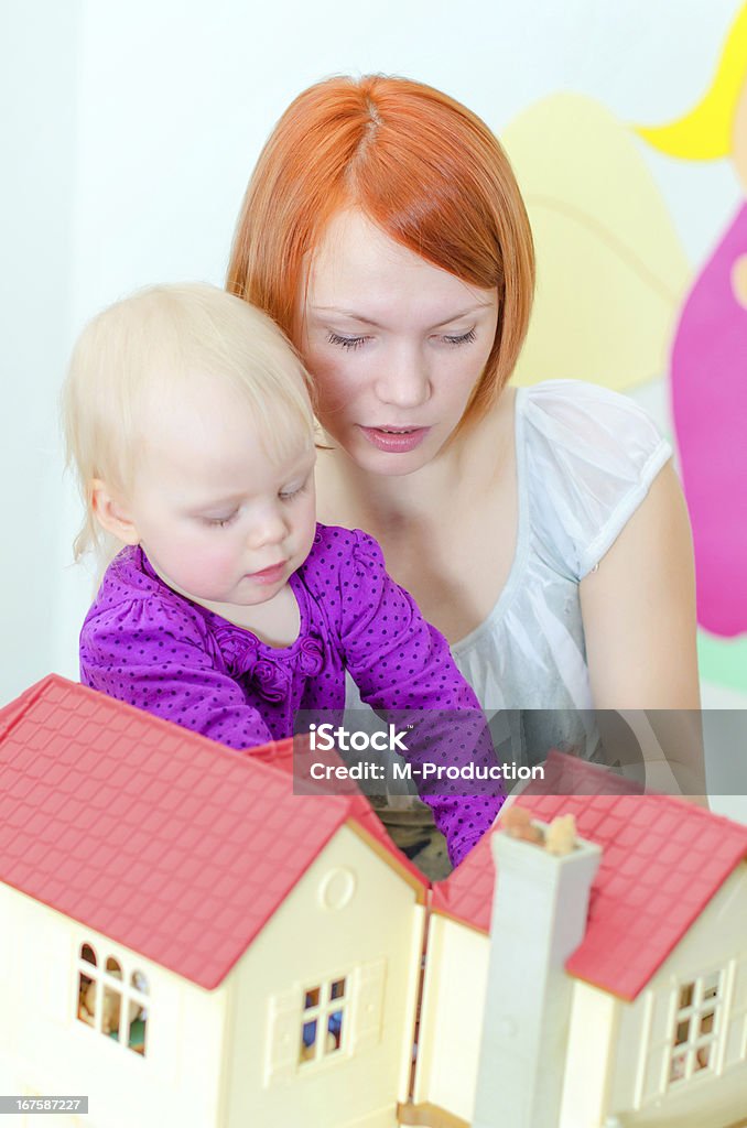 Bambino e la madre giocano con Casa delle bambole - Foto stock royalty-free di Adulto