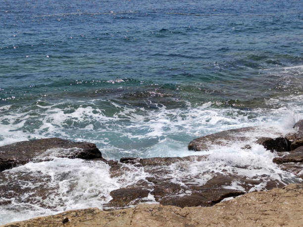 istock small sea waves splashing the rocks 1675876829