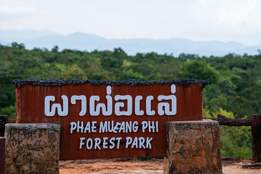 Nilgiri Hills, India - October 26, 2013: Mudumalai Tiger Reserve sign along road in Masamigulli Forest. Sign as gate over asphalted road. Blue sky and green vegetation.