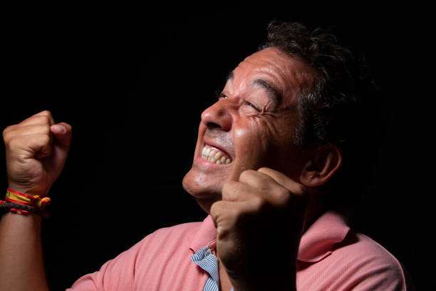istock Middle-aged dark-haired man wearing a light-colored polo shirt on a black background 1675893213