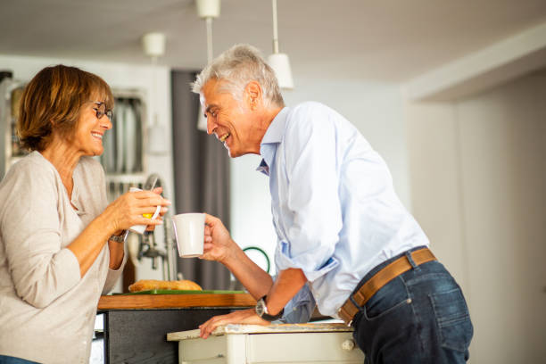 Portrait happy couple drinking tea in kitchen