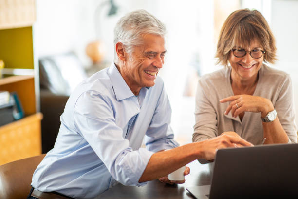 istock happy older couple sitting with laptop 1675915176