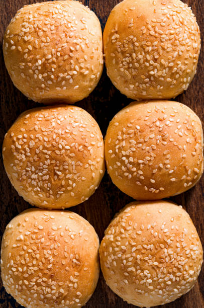 istock Burger bread buns in a row with sesame seeds on top, small size 1675915717