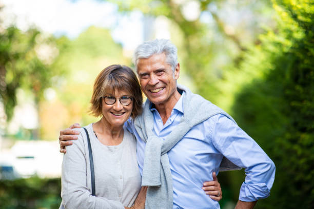 istock smiling older couple standing outside in park 1675916328