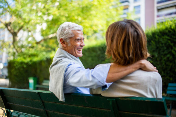 istock behind happy couple sitting on park bench 1675921365