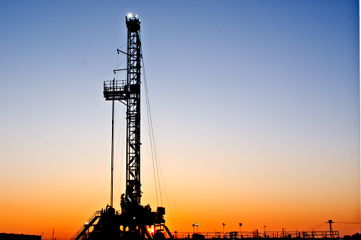 An oil drilling rig set up on Route 66 near Sapulpa, Oklahoma.  Photo was shot at sunrise.