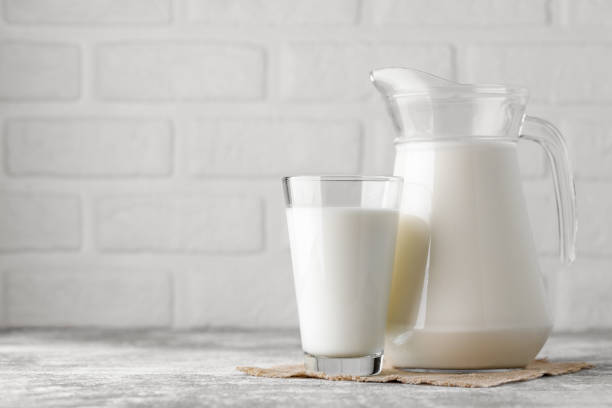 istock milk in jug and glass on table with white brick wall as background 1675931796