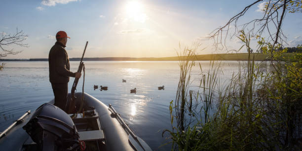 istock hunter with the shot gun on a sunset background. Duck hunter. Banner with copy space. 1675932321