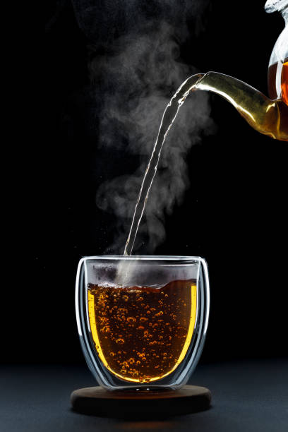 istock hot tea pouring from teapot into glass cup 1675935002