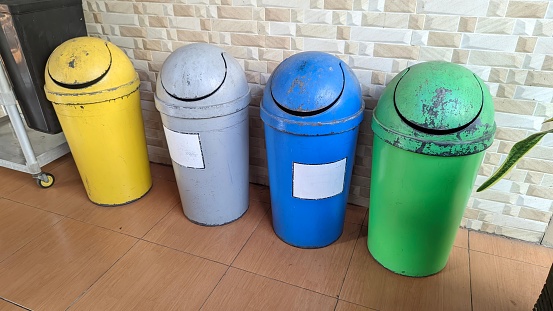 Colorful trash cans line an open room