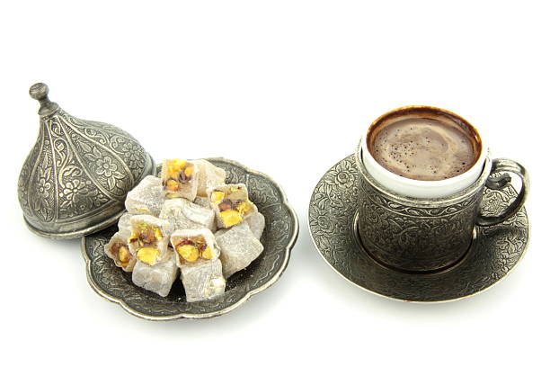 Delicious Turkish coffee and turkish delight with pistachio nuts on white background.