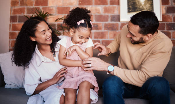 istock Family, happy and laughing while playing on a home sofa with tickle fun, bonding and time together. A happy man, woman and girl kid in a lounge with love, care and happiness in house in Puerto Rico 1675964761