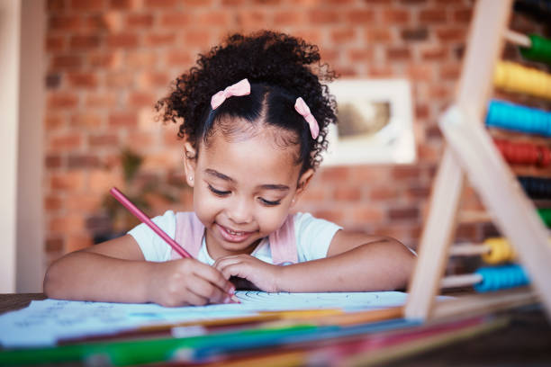 istock Homework, writing and child drawing at home with study, learning and smile for project. Young girl, problem solving and youth development at house with student education and notes at table for school 1675968272