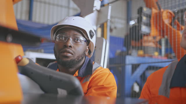 Professional Engineer Working On Industrial Robots In A Factory.