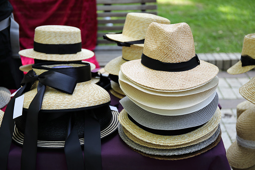 several straw fashion hats in a street market