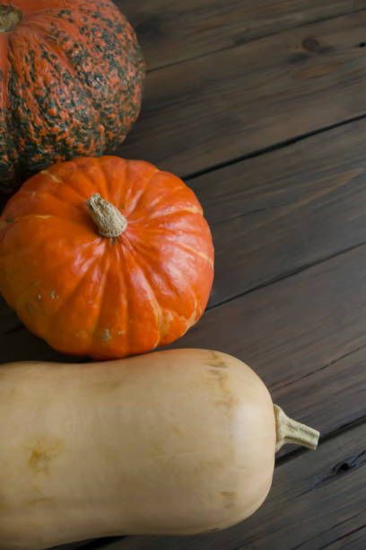 istock Three pumpkins on a wooden table. decorative pumpkins. Autumn decorations for Halloween. 1675973171