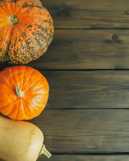 istock Three pumpkins on a wooden table. copy space. Autumn pumpkins are Halloween decorations. row with pumpkins 1675973693