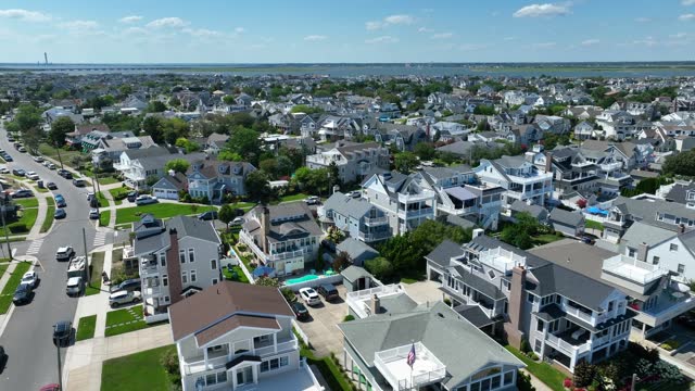 Beach town in USA. Aerial shot of expensive houses, homes, rentals, and Airbnb. Beautiful summer day in neighborhood at beach.