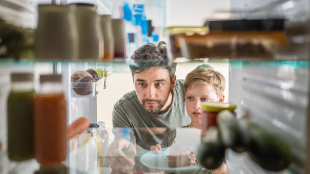 Father with his son looking into refrigerator