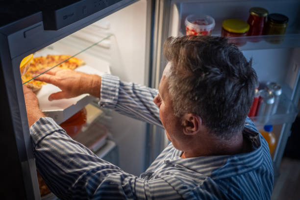istock Man takes out pizza from refrigerator 1676004210