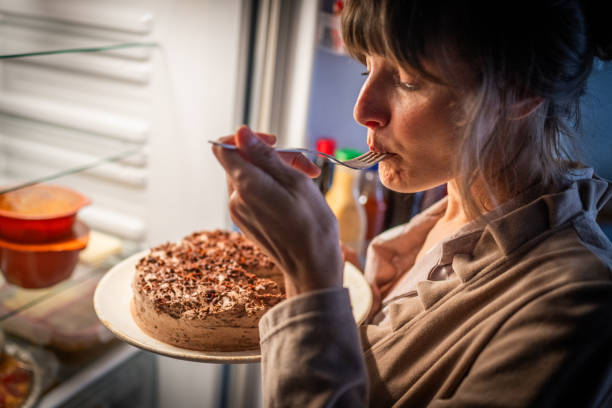 Mulher comendo bolo - foto de acervo