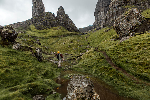 Male hiker enjoying the freedom of the single life at the Old man of Storr in Scotland