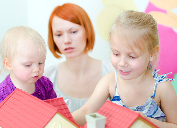 istock Children and their mother playing with dollhouse 167602855