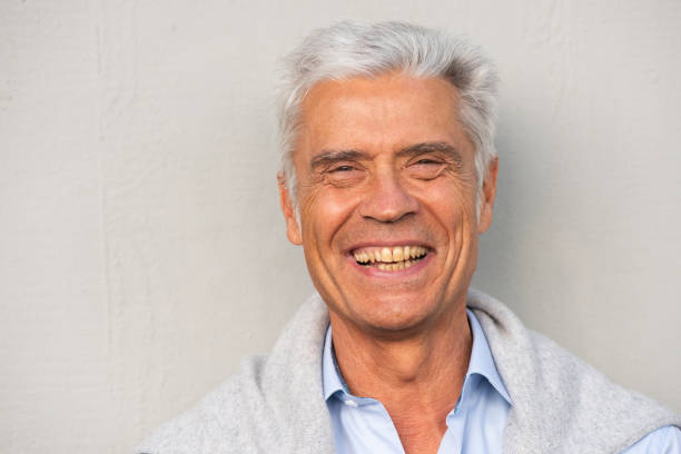 istock Close up smiling older man against white wall 1676039196