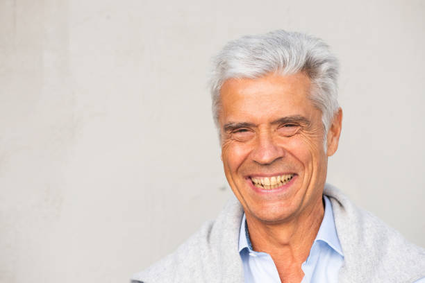 istock Close up older man smiling against white wall 1676039707