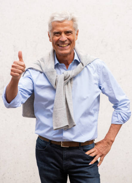 istock handsome older man with thumbs up hand sign 1676040726