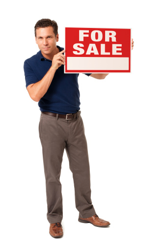 Man holding FOR SALE sign