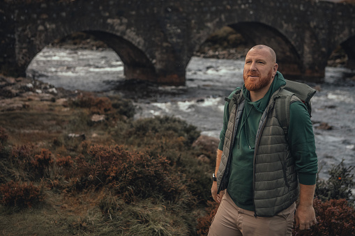 Male hiker enjoying the beautiful countryside landscape of the highlands in Scotland